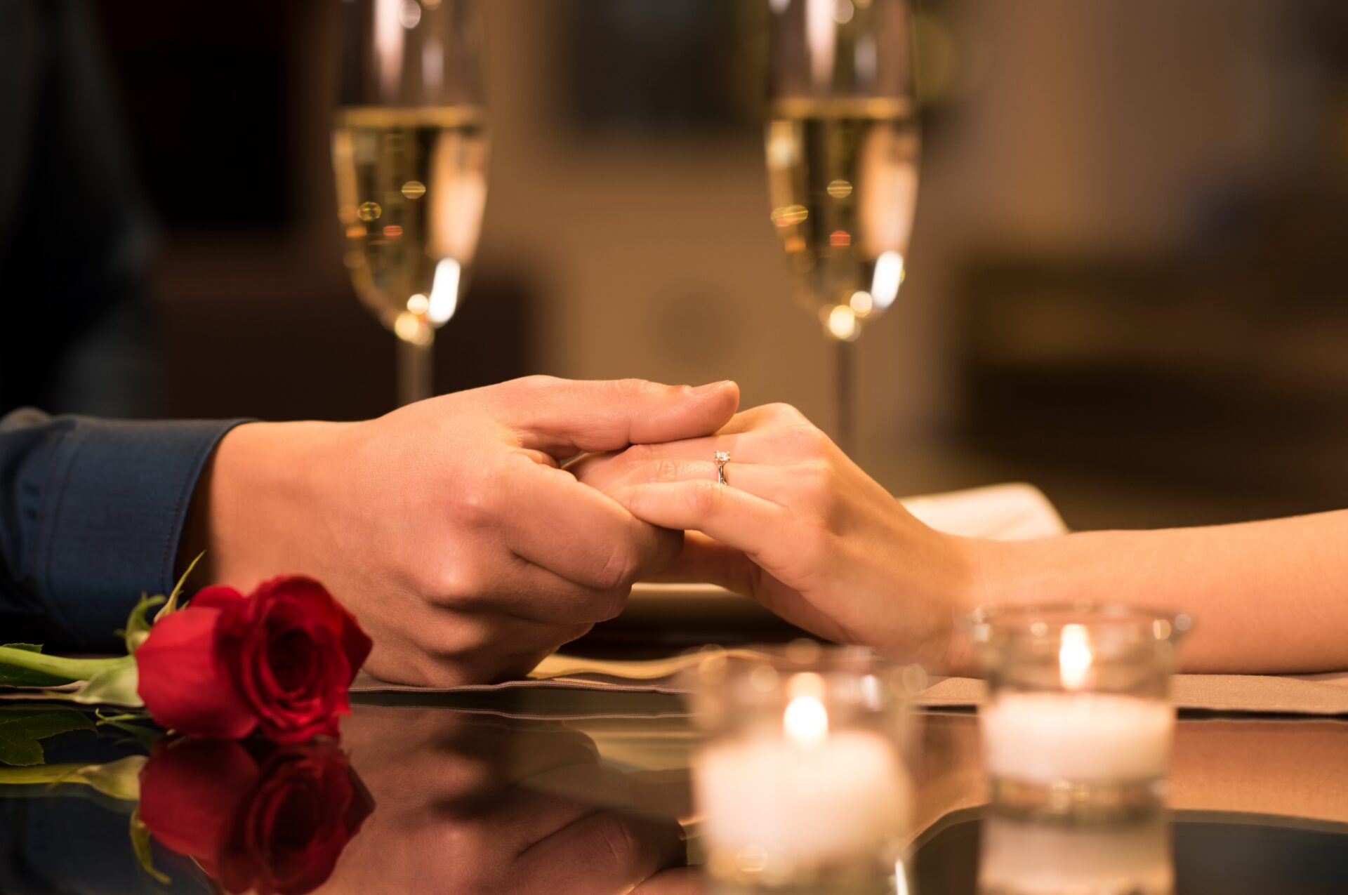 Closeup,Of,Couple,Hands,On,Restaurant,Table,With,Two,Glasses